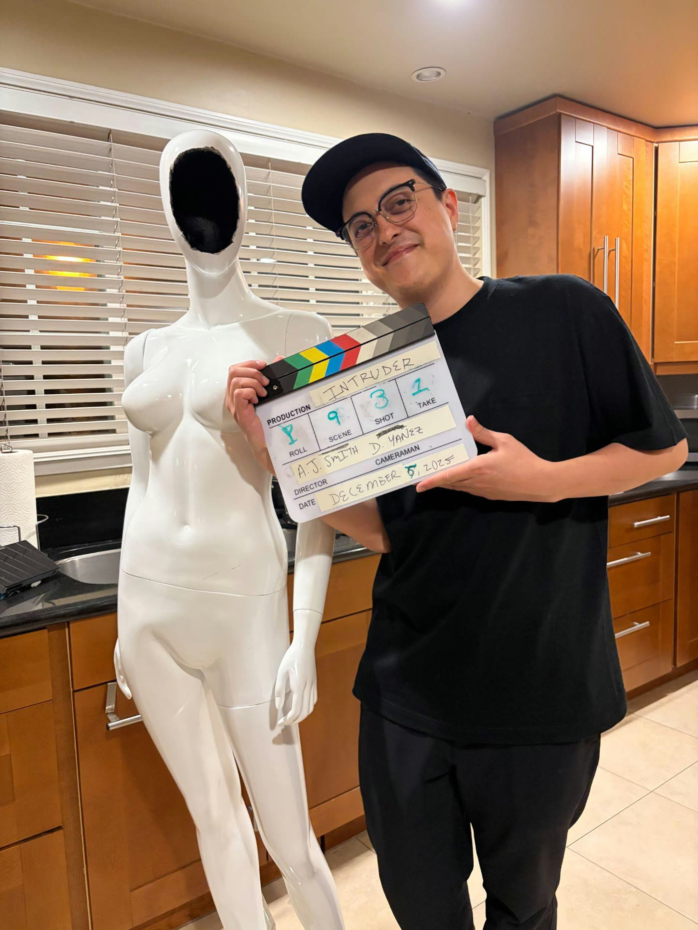 Austin with the mannequin and a clapperboard in the kitchen.