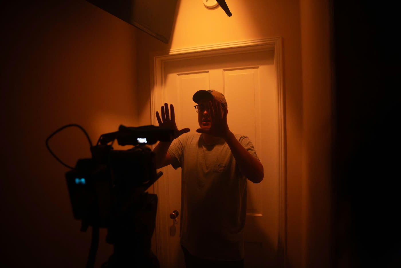 Camera operator waves by the bedroom door.